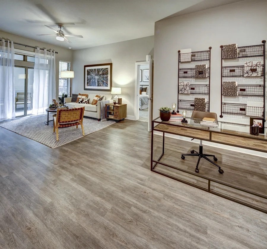 A living room with a wooden floor and a ceiling fan at Arise Riverside Apartments, Austin, TX