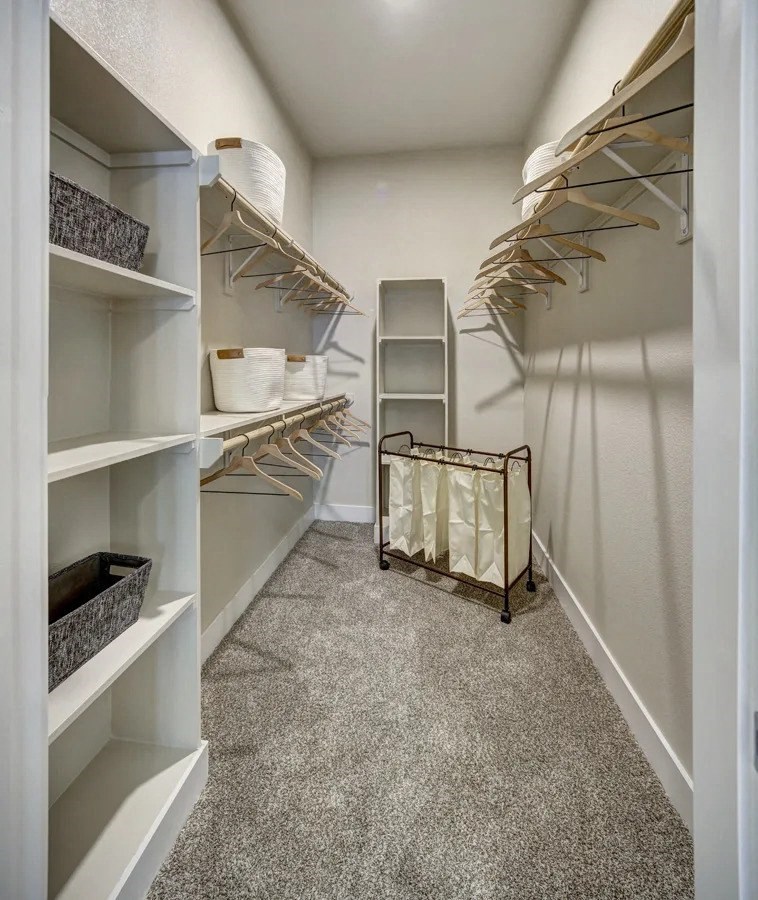 A walk-in closet with white shelves and hangers at Arise Riverside Apartments, Austin
