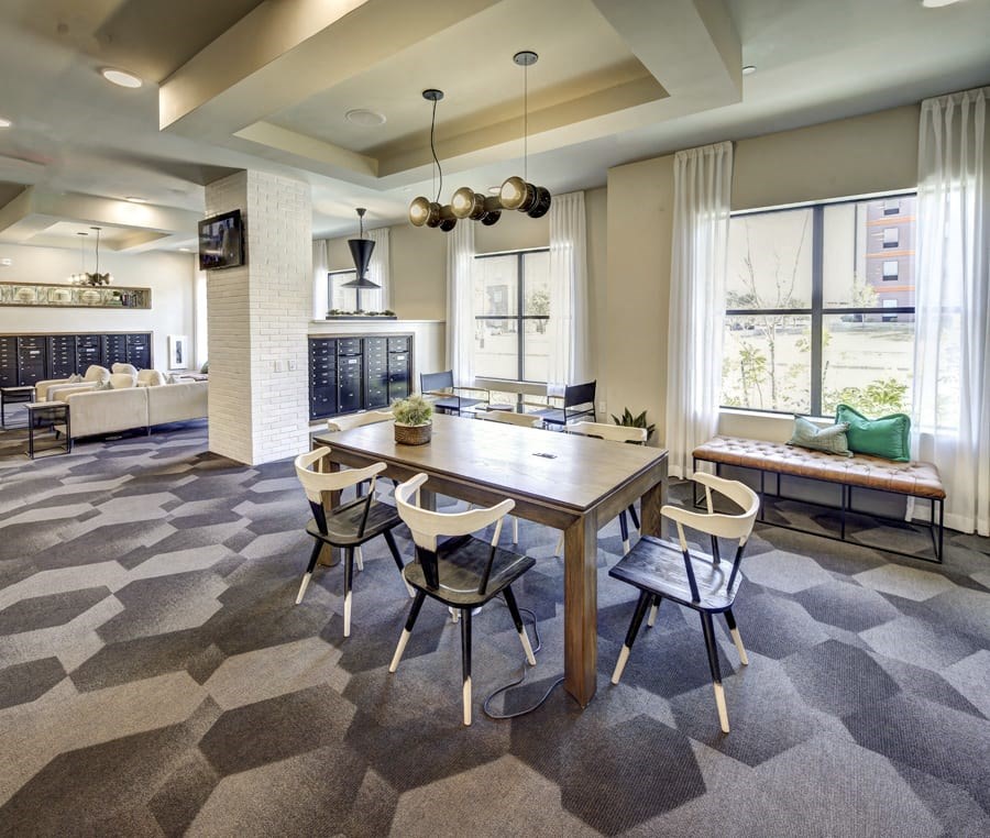 A modern dining room with a wooden table and chairs at Arise Riverside Apartments, Texas