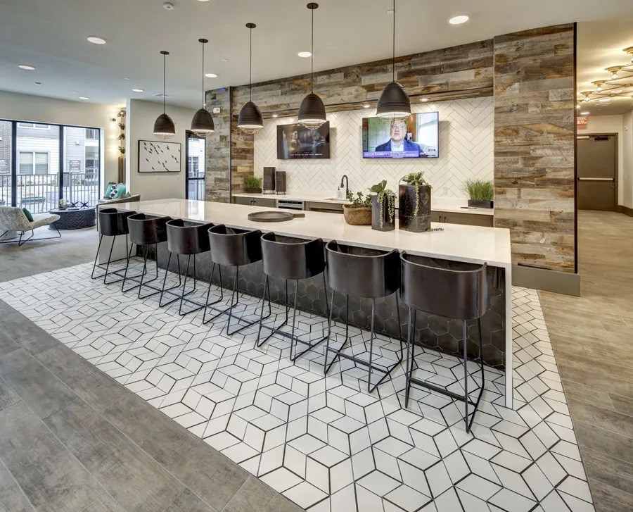 A modern kitchen with a long island and bar stools at Arise Riverside Apartments, Austin, TX