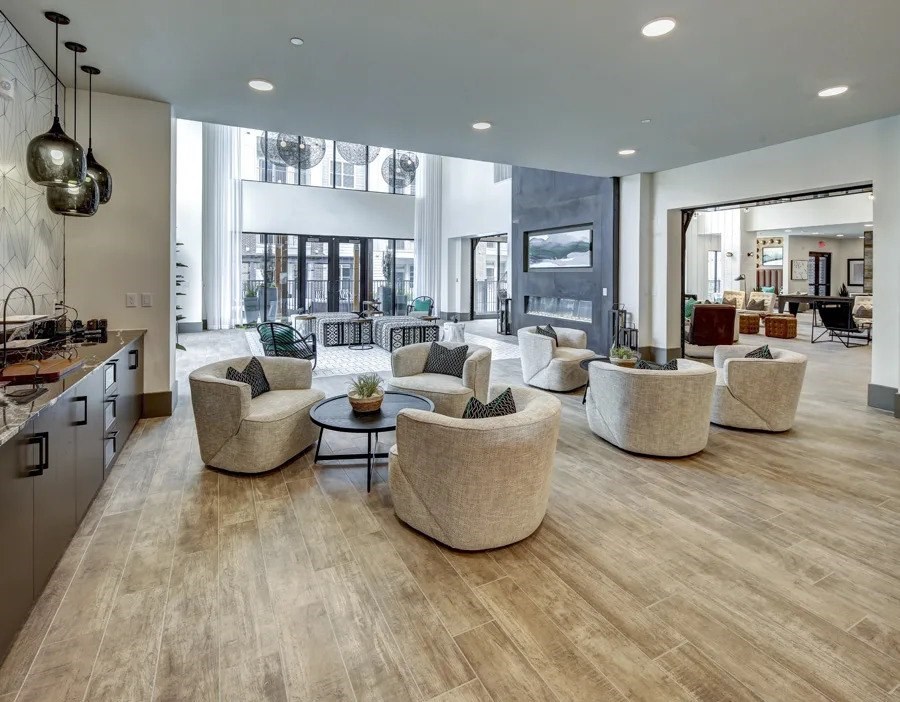 A modern living room with a kitchen area and a dining area at Arise Riverside Apartments, Austin, Texas