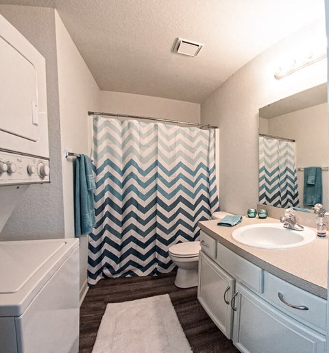 a white bathroom with a blue and white shower curtain