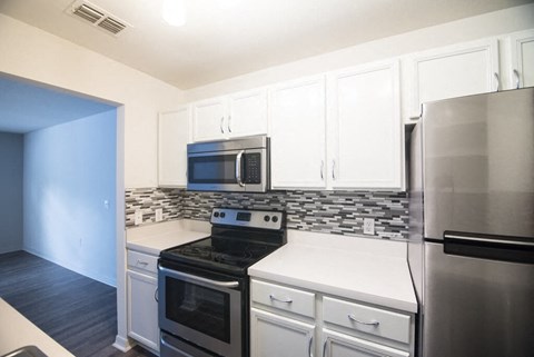 a kitchen with stainless steel appliances and white cabinets