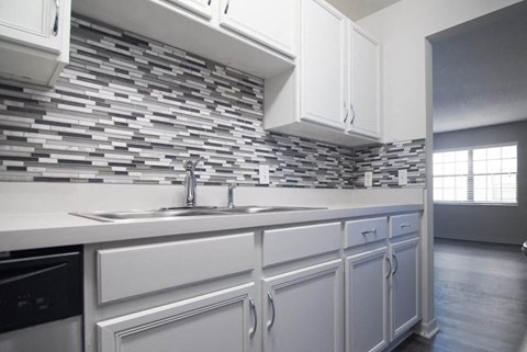 a kitchen with white cabinets and a sink