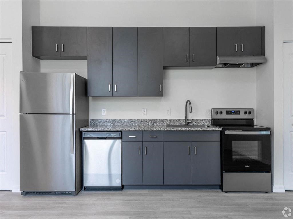 a kitchen with stainless steel appliances and gray cabinets