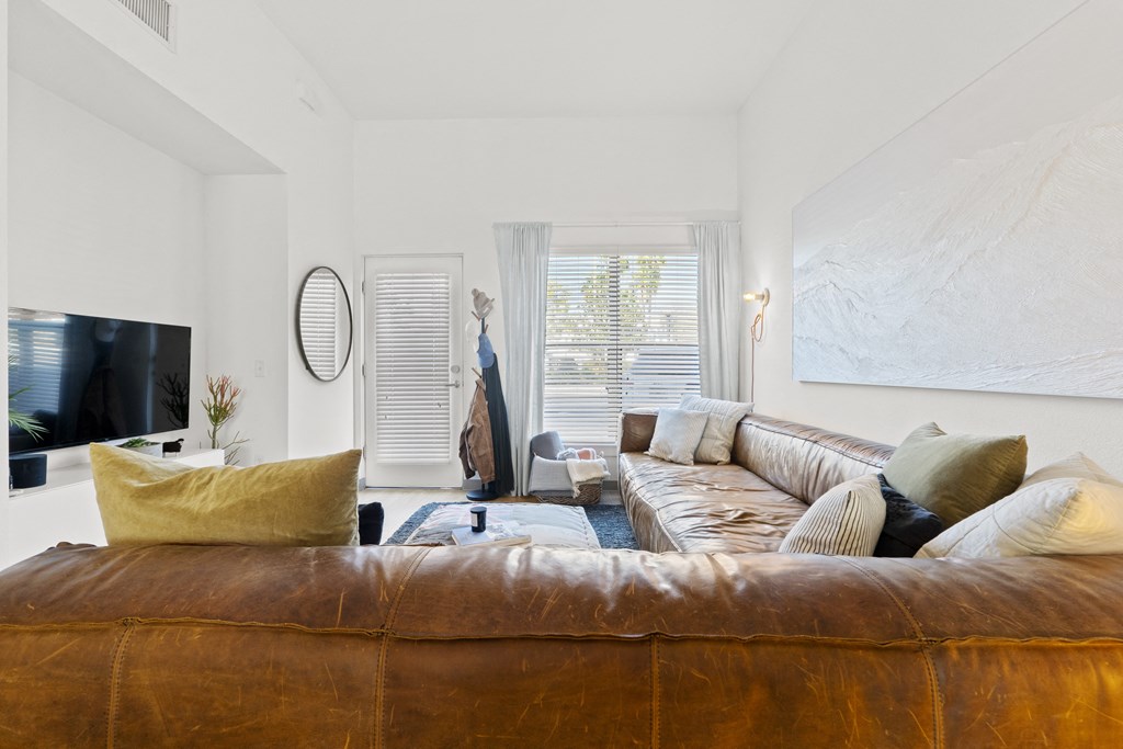 a living room with a leather couch and a tv