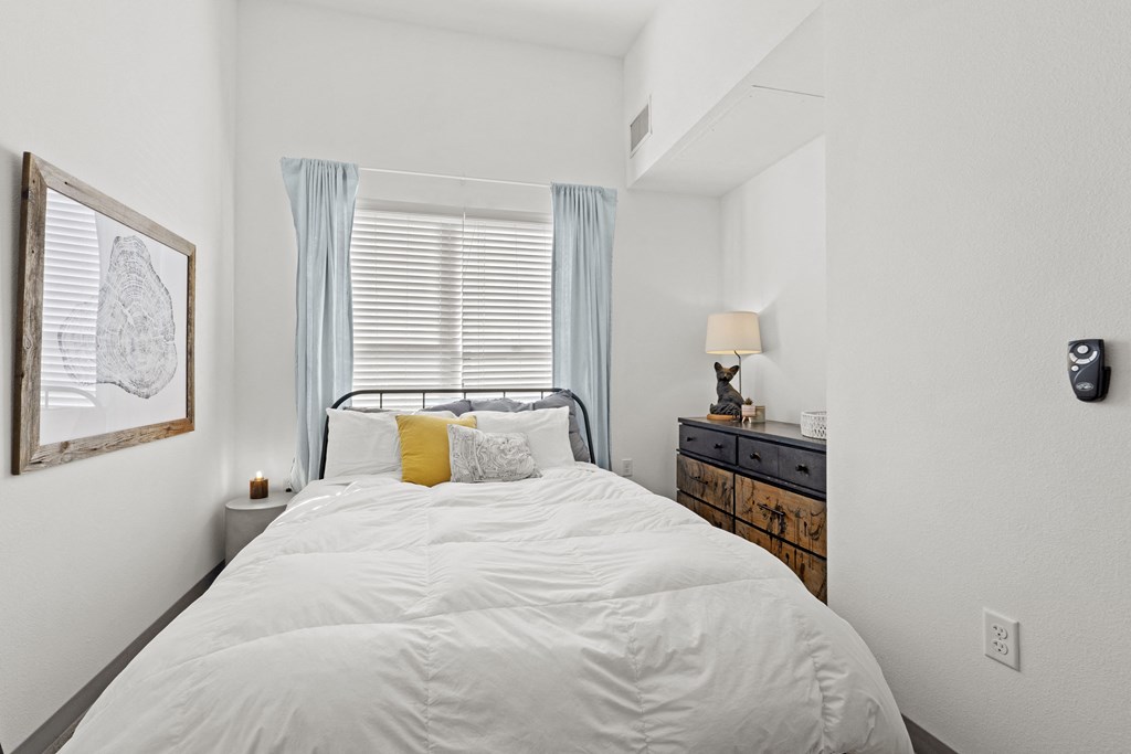 a bedroom with a white bed and a window
