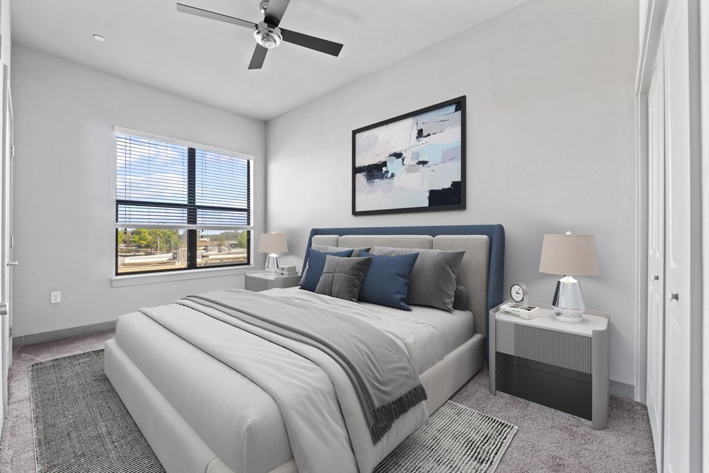 a white bedroom with a white bed and a ceiling fan