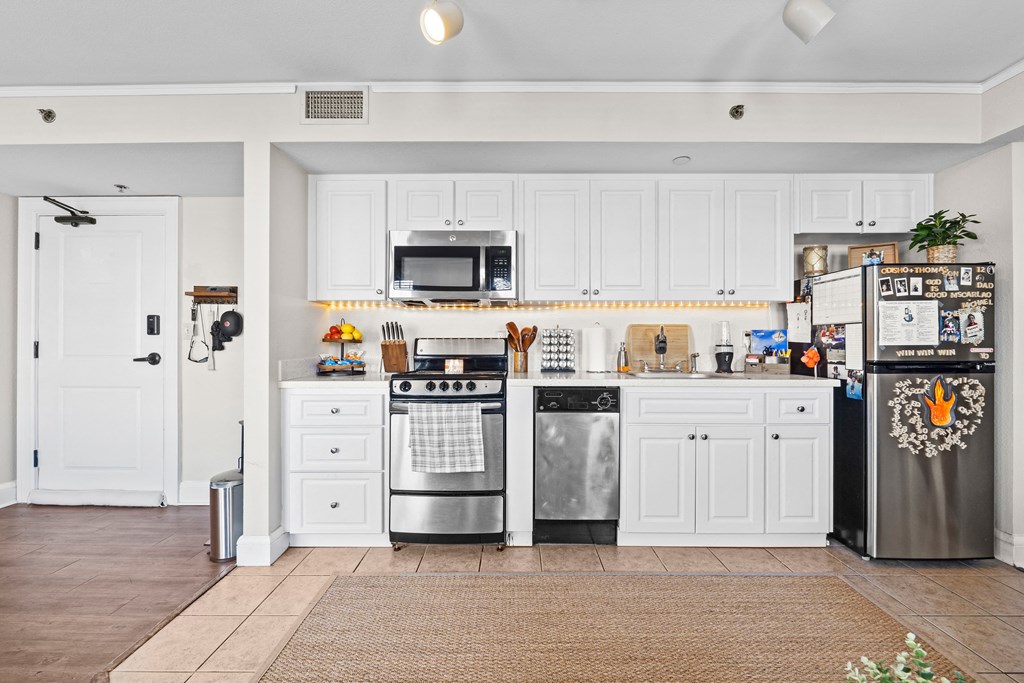 a kitchen with stainless steel appliances and white cabinets