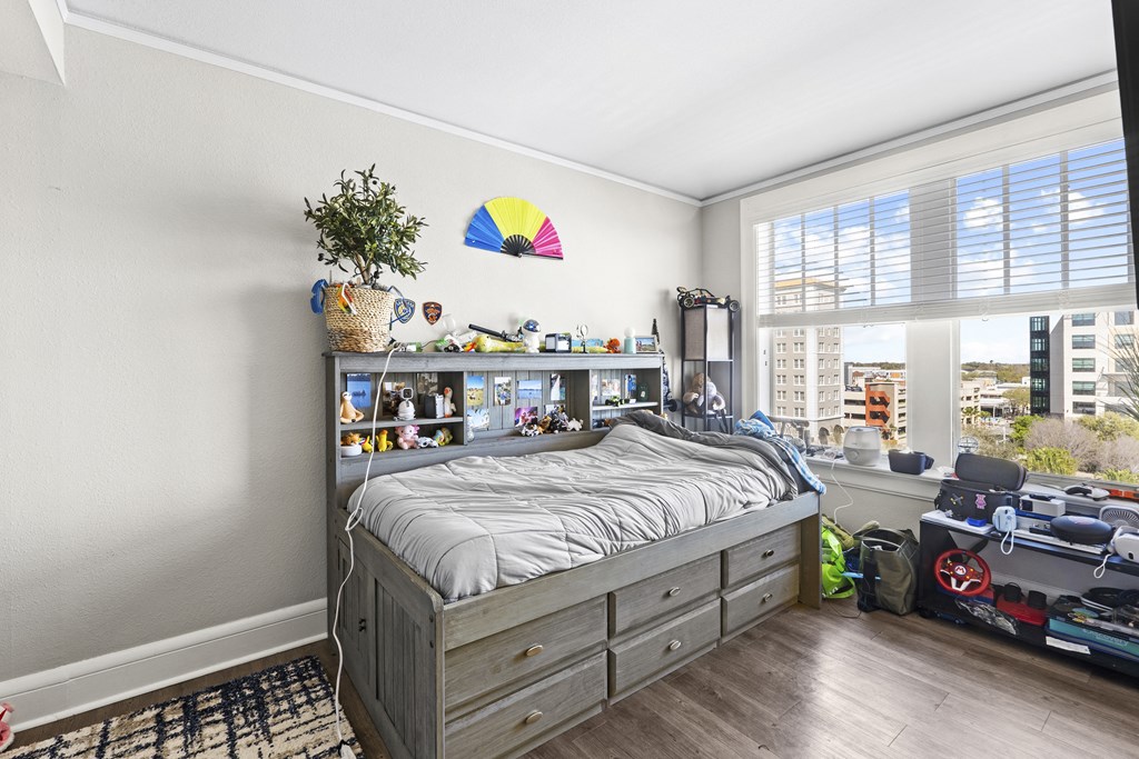 a bedroom with a bed and a dresser and a window