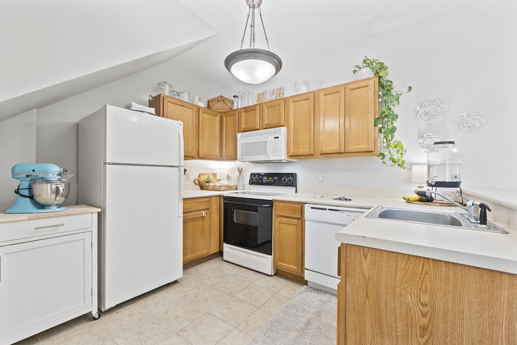 a kitchen with white appliances and wooden cabinets