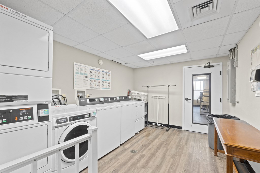 a laundry room with a washer and dryer and a table and a door