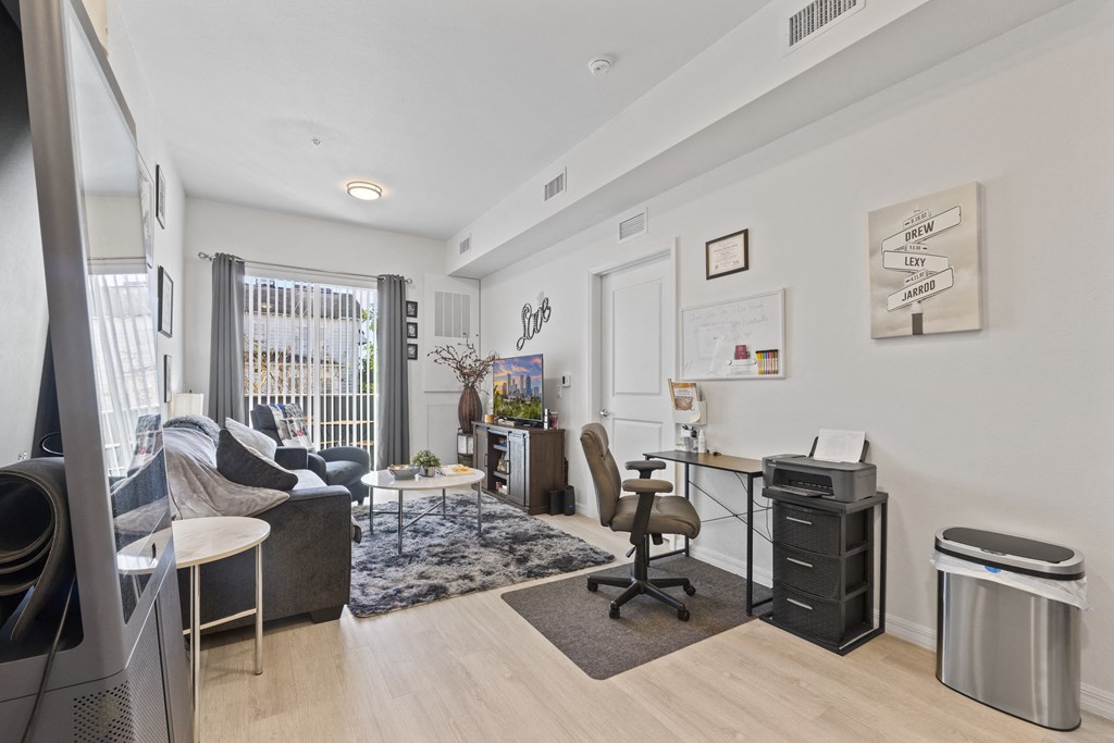 a living room with a couch and a desk and a window