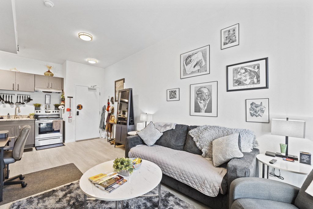 a living room with a gray couch and a white table
