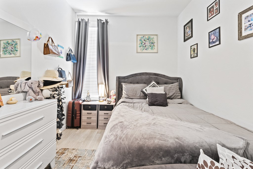 a bedroom with a bed and a dresser and a window