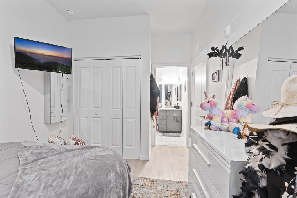 a bedroom with white walls and a bed and a white dresser