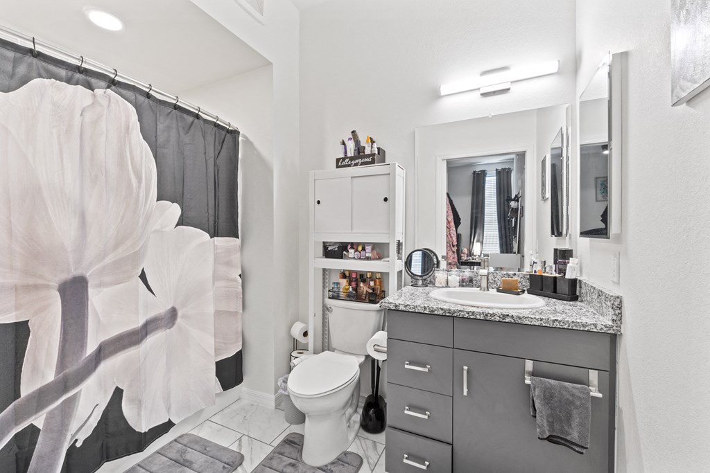 a bathroom with a shower and a sink and a toilet