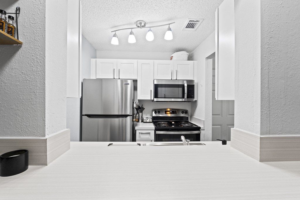 a kitchen with stainless steel appliances and white cabinets