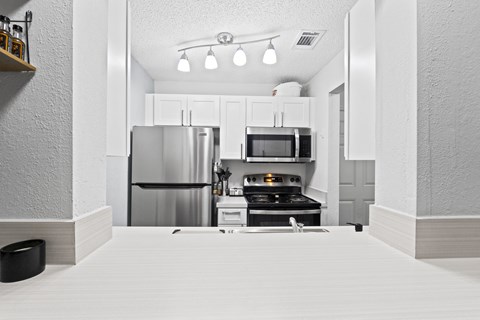 a kitchen with stainless steel appliances and white cabinets