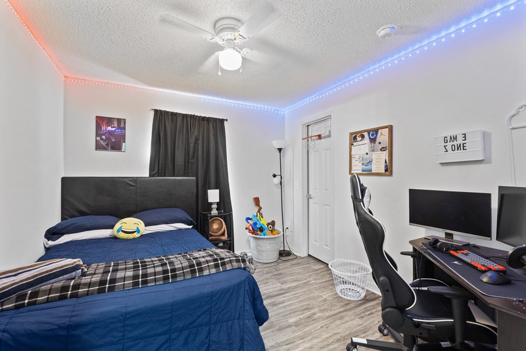 a bedroom with a bed and a desk and a tv