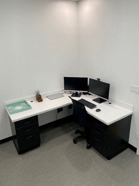 a room with two desks and two computer monitors