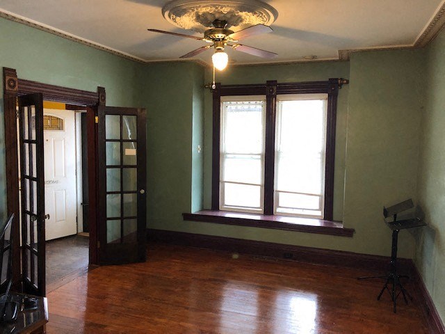 a living room with a ceiling fan and two windows