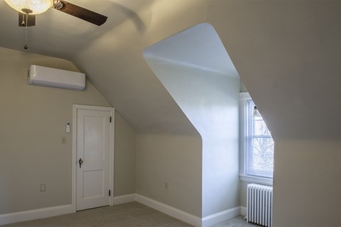 a white room with a white door and a ceiling fan