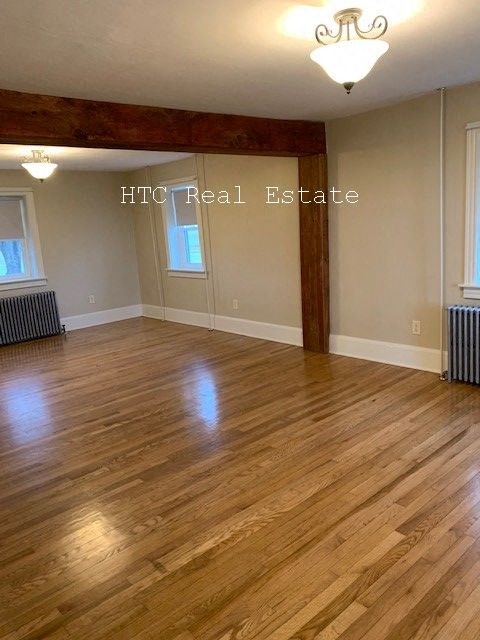 A room with wooden floors and a chandelier.