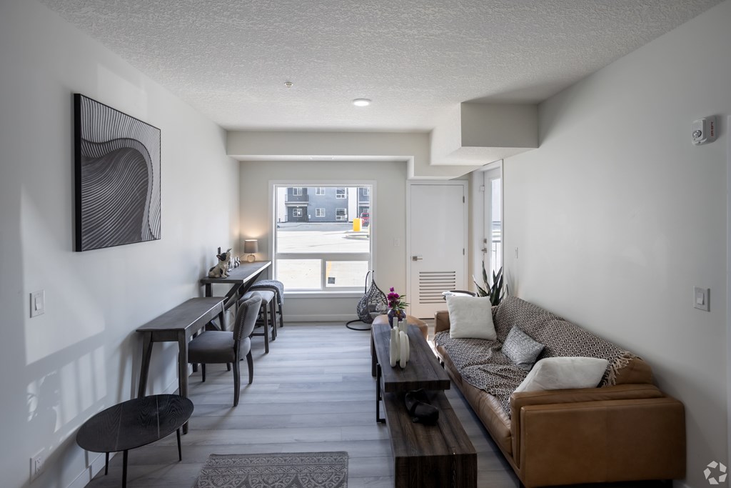A modern living room with a brown couch and a dining table.