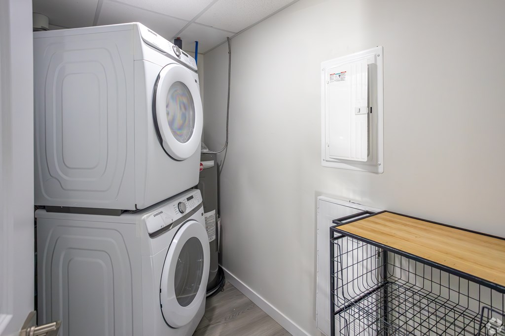 A laundry room with a washer and dryer stacked on top of each other.