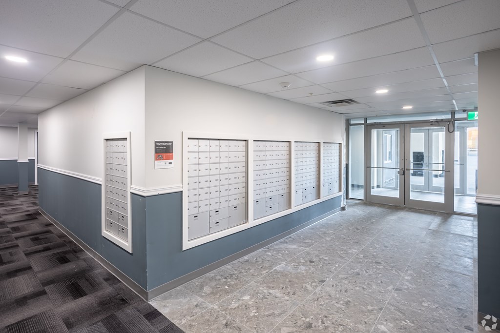 A hallway with a series of lockers on the wall.
