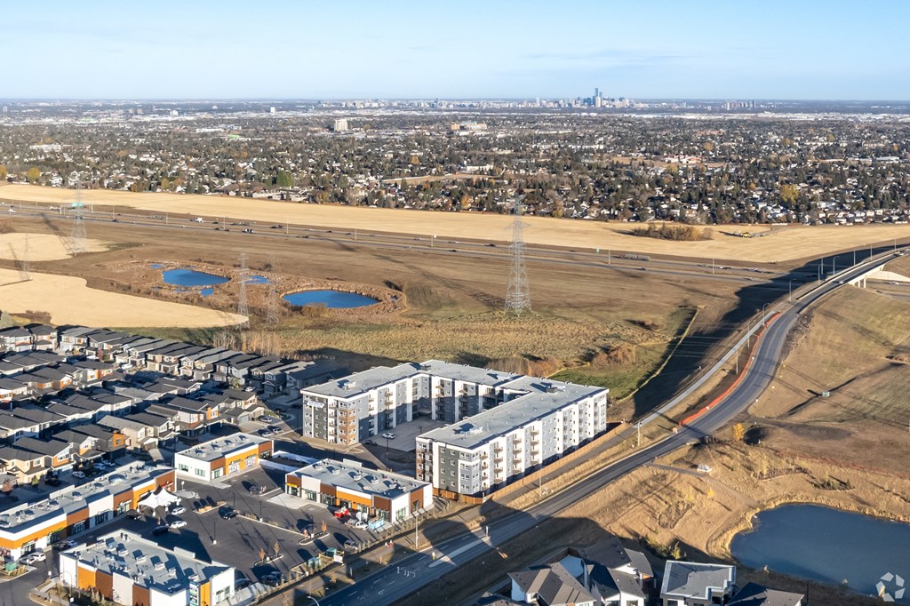 A large building complex is situated in a field with a road running through it.