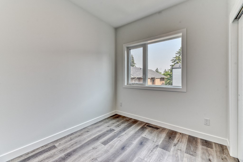A room with a window showing a view of a house.