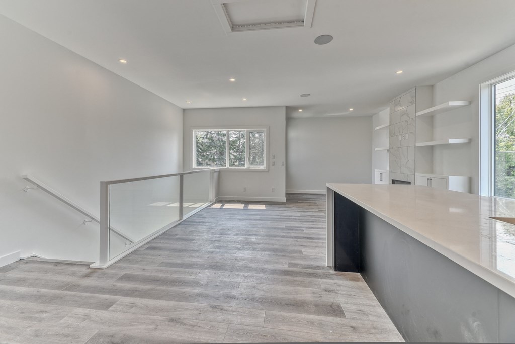A spacious room with a staircase and a window.