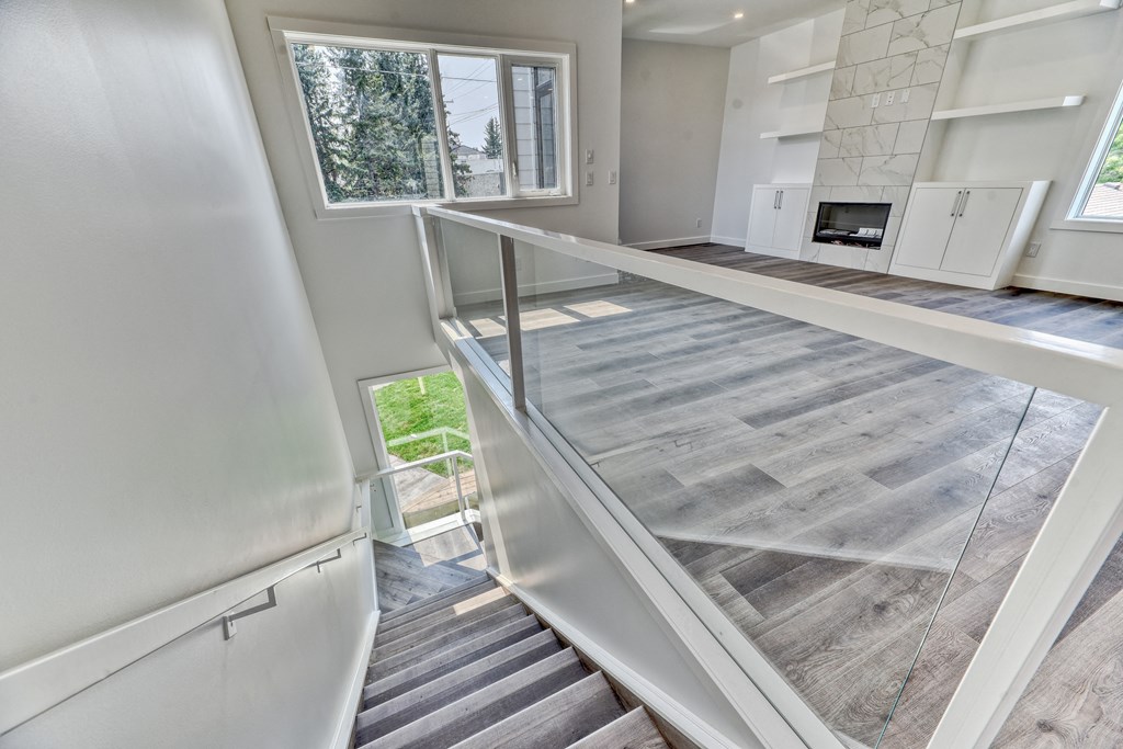 A modern interior with a staircase leading to a balcony.