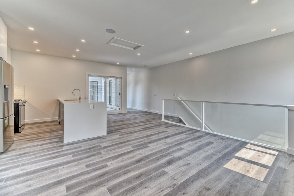 A spacious room with wooden flooring and a white counter.