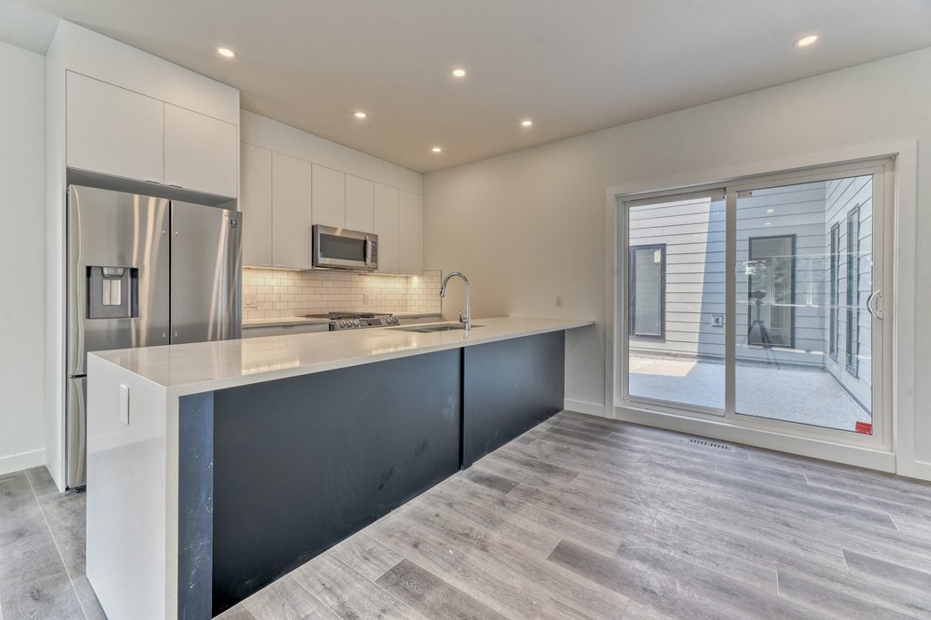 A modern kitchen with a large island and stainless steel appliances.