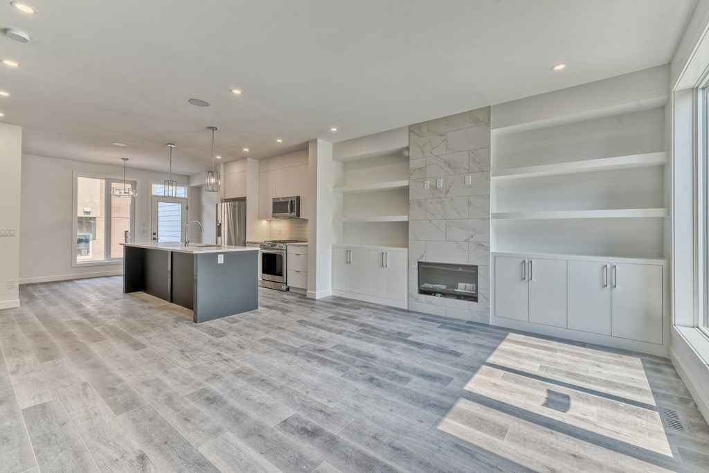 A spacious kitchen with a grey island and white cabinets.
