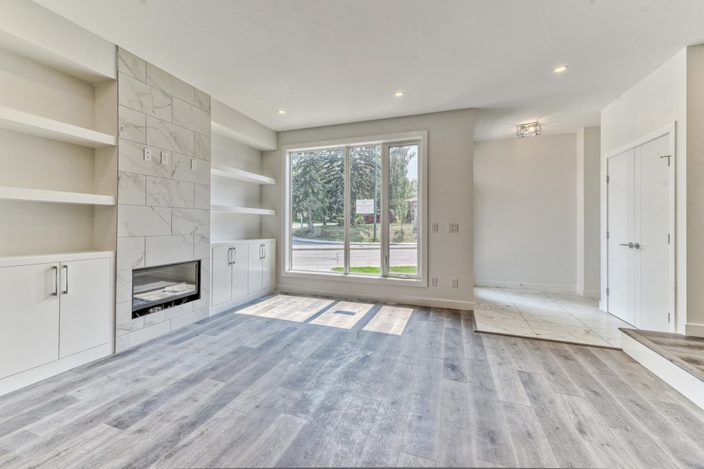 A spacious living room with a fireplace and a large window.
