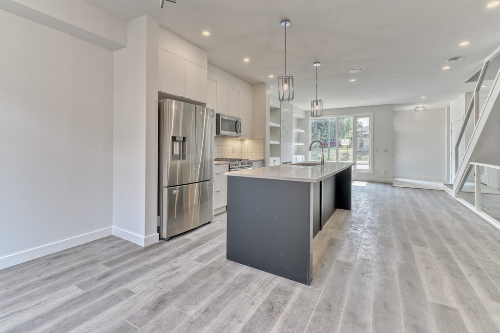 A kitchen with a large island and stainless steel appliances.