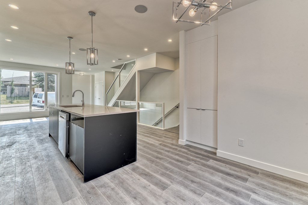 A modern kitchen with a black island and stainless steel appliances.