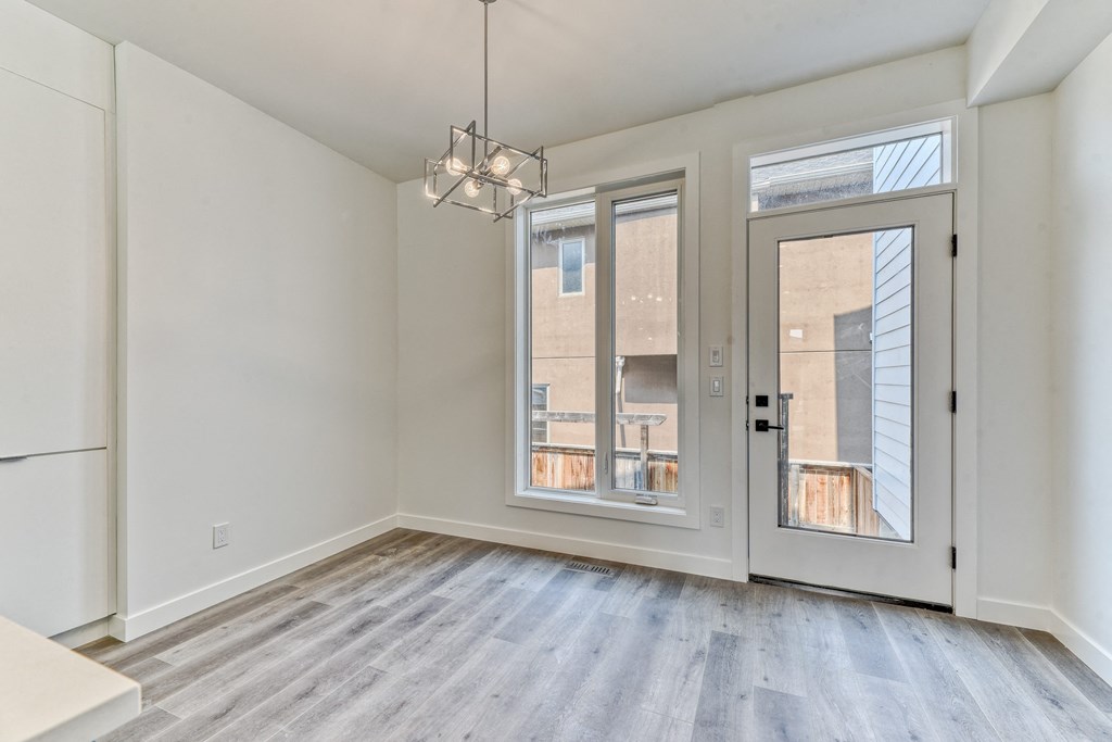 A room with a large window and a door leading to a balcony.