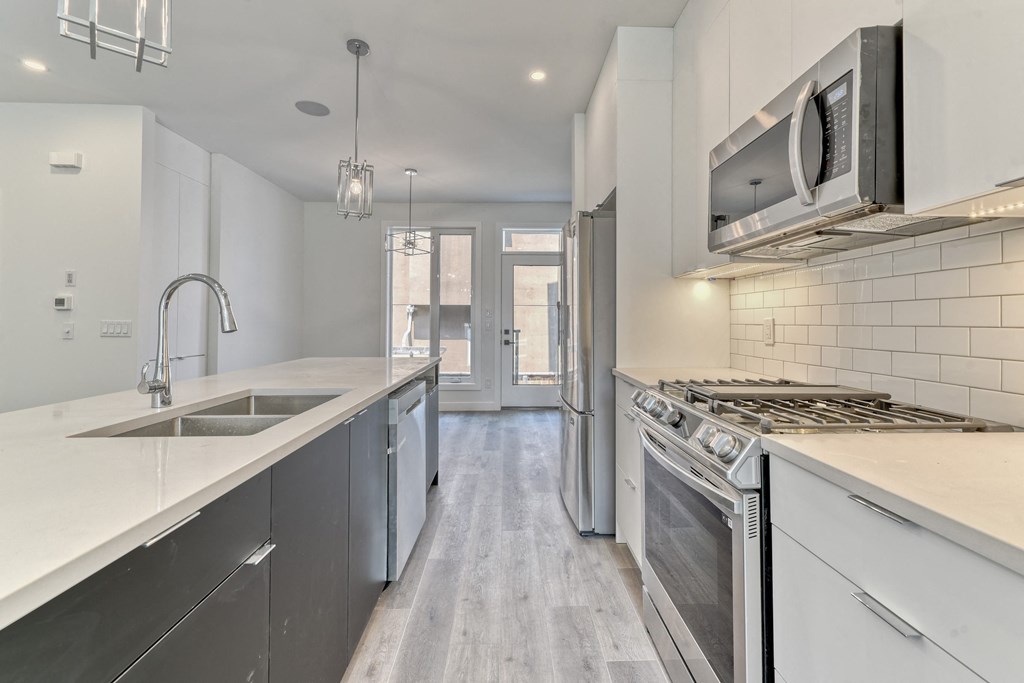 A modern kitchen with stainless steel appliances and white cabinetry.
