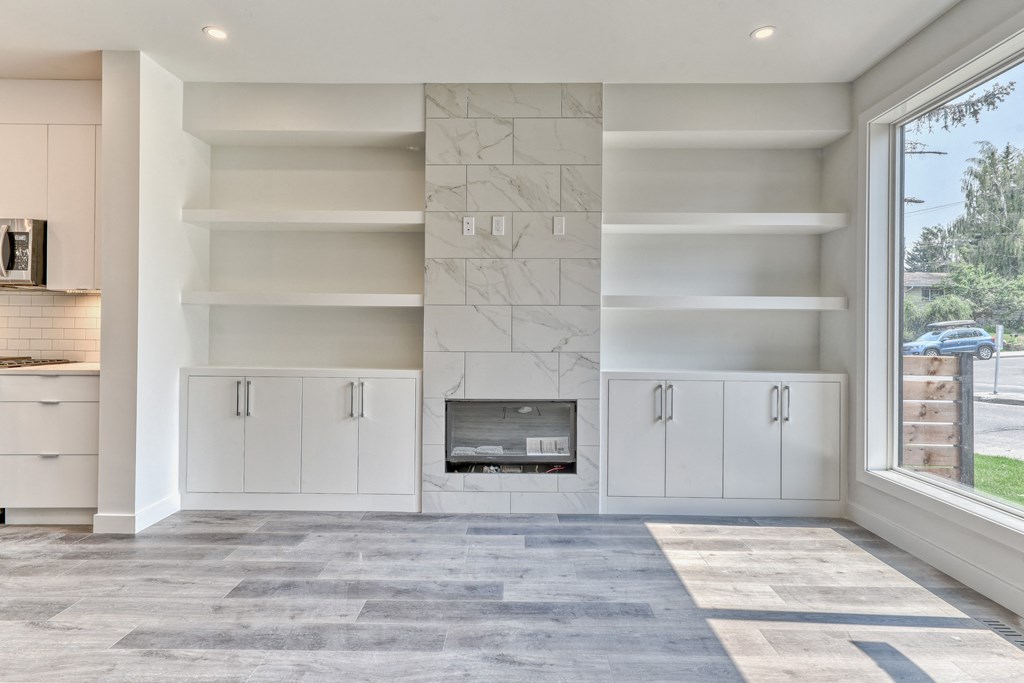 A modern living room with a fireplace and built-in shelves.
