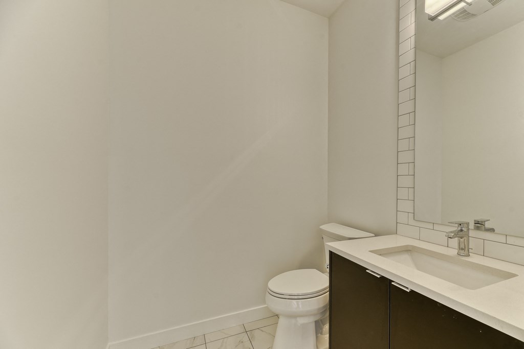 A white toilet sits next to a sink in a bathroom.