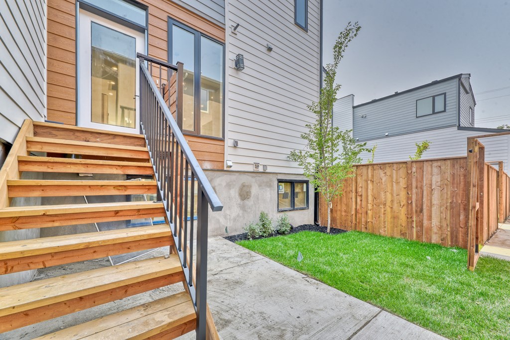A house with a wooden staircase leading to a glass door.