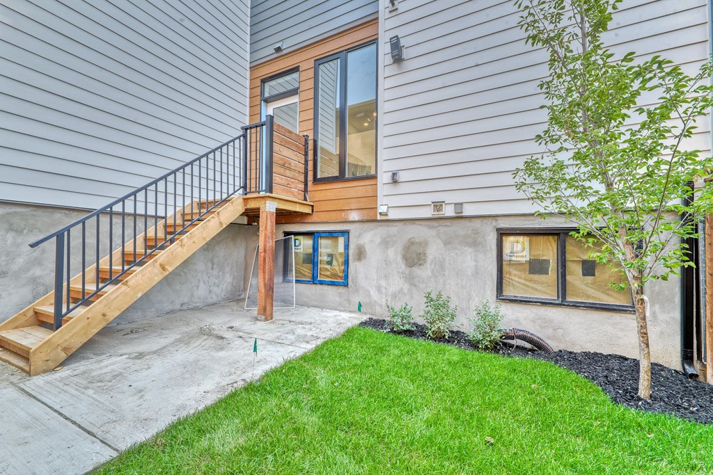 A house with a wooden deck and a tree in front.