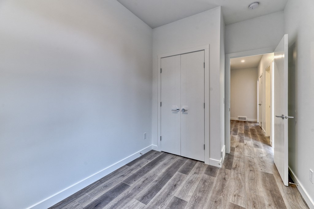 A hallway with a white door and a grey floor.
