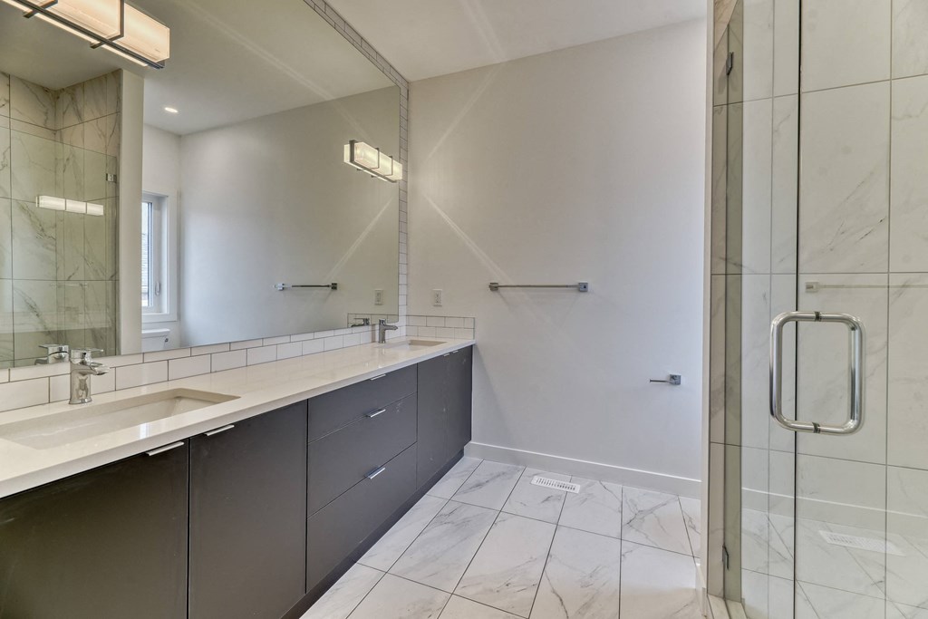 A bathroom with a white sink and a mirror.