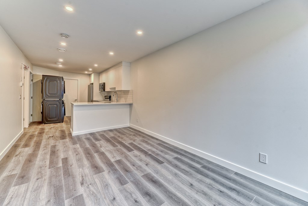 A room with a wooden floor and a white wall.